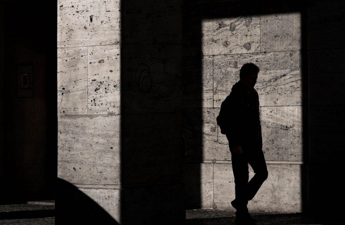 Silhouette on the wall of a man walking.