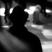 Silhouette of man standing in the train station watching people.