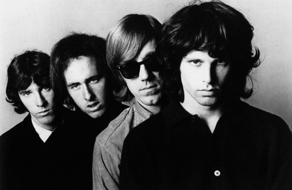 Black and white photo of The Doors band members with Jim Morrison in the front.