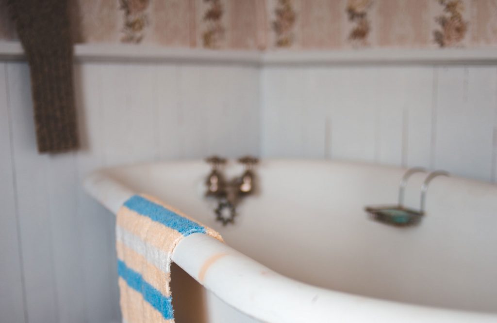 An empty vintage style bathtub in a bathroom.