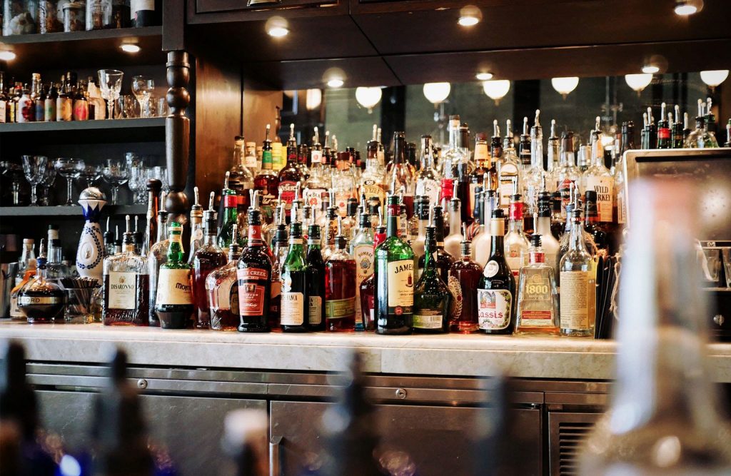 Alcoholic beverages on display behind a bar counter.