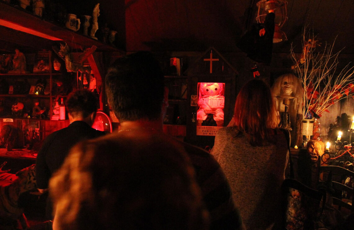 A crowd of people look on at the haunted Annabelle doll.