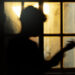 Silhouette of a person standing near a window.